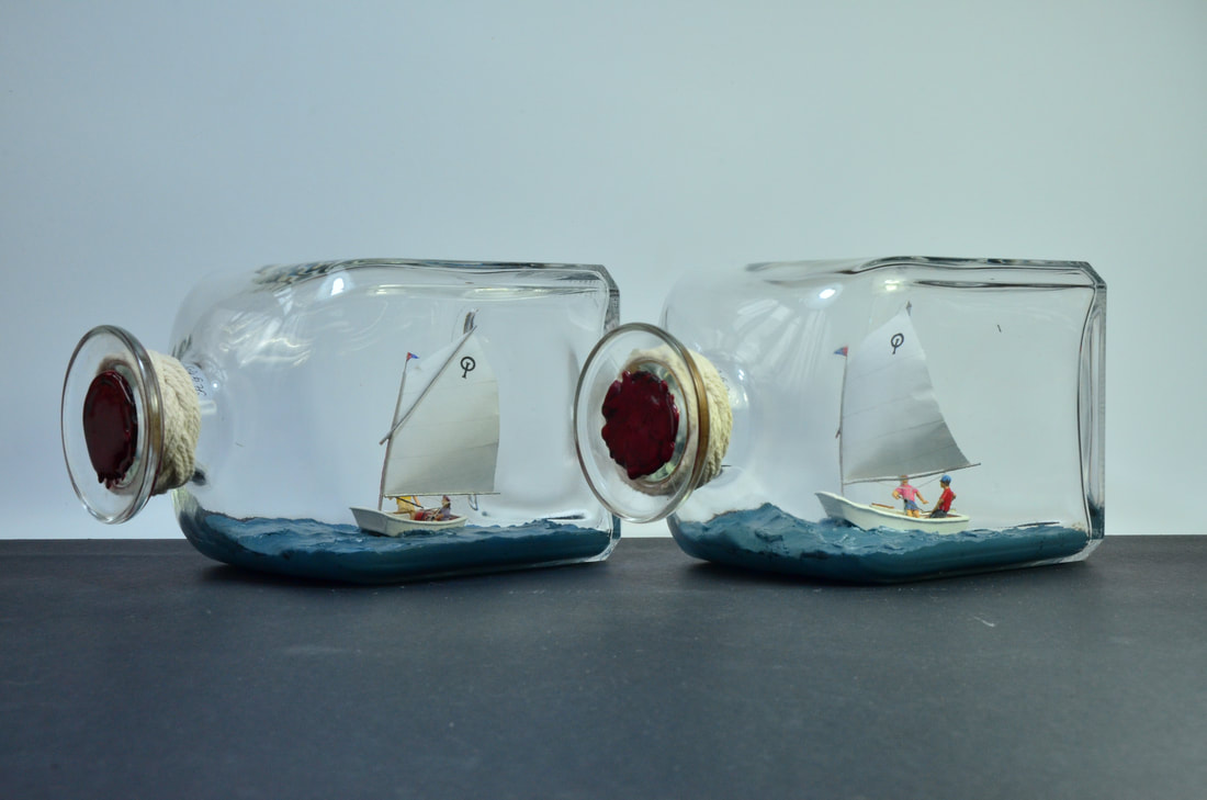 Two ships in bottles of optimist sailing dinghies