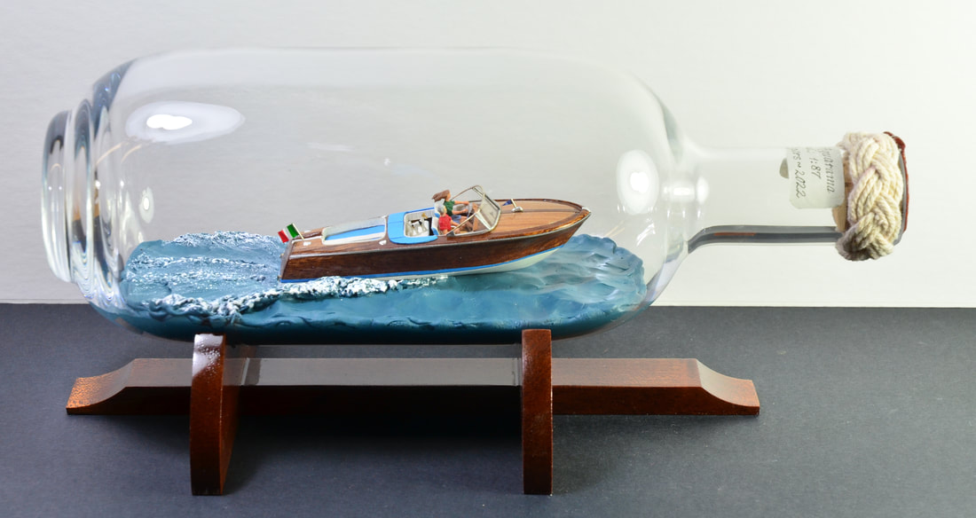 1970 Riva Aquarama powerboat displayed under power inside of a bottle.