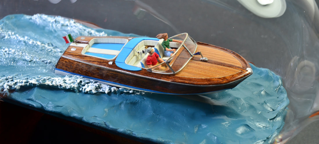 Miniature model of the riva Aquarama, luxury runabout, inside of a clear blown bottle.