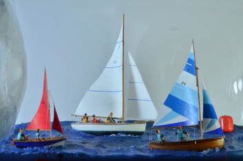 The crew adjust the sails on the miniature sailing yacht models in this hand crafted diorama.